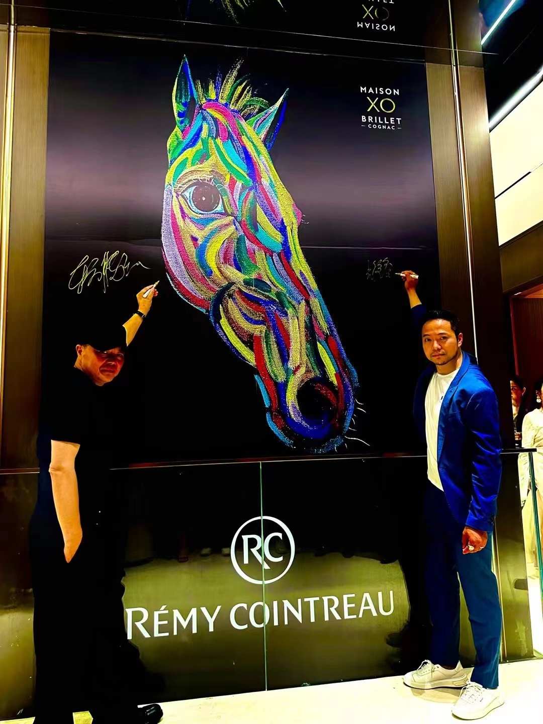 东方腾弘与合作方在Rémy Cointreau品牌展墙前合影